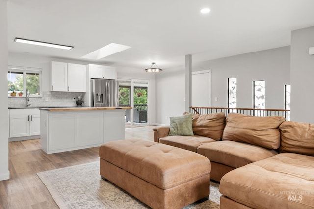 3513 7th St E, Lewiston, ID 83501 - living room featuring a skylight, light wood-type flooring, healthy amount of natural light, and recessed lighting