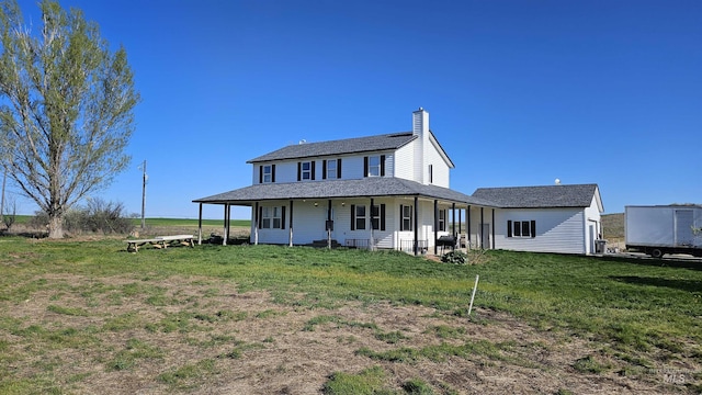 rear view of house with a yard and a chimney