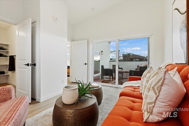 living room featuring a towering ceiling and light wood-type flooring