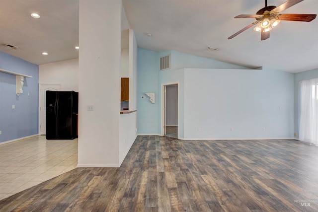 empty room with hardwood / wood-style flooring, ceiling fan, and vaulted ceiling