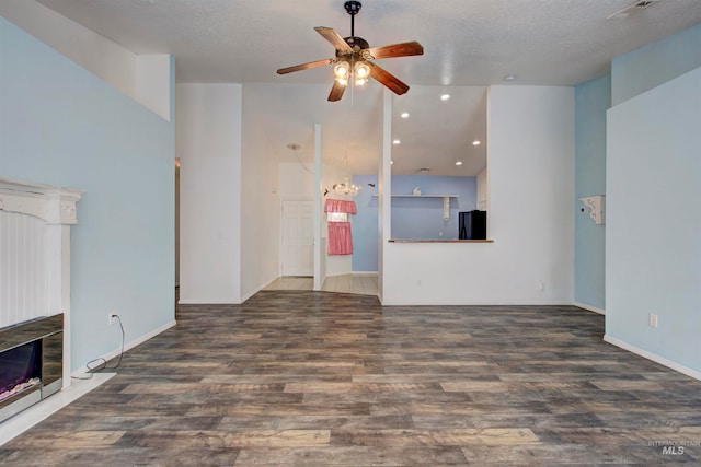 unfurnished living room with ceiling fan, dark hardwood / wood-style flooring, lofted ceiling, and a textured ceiling