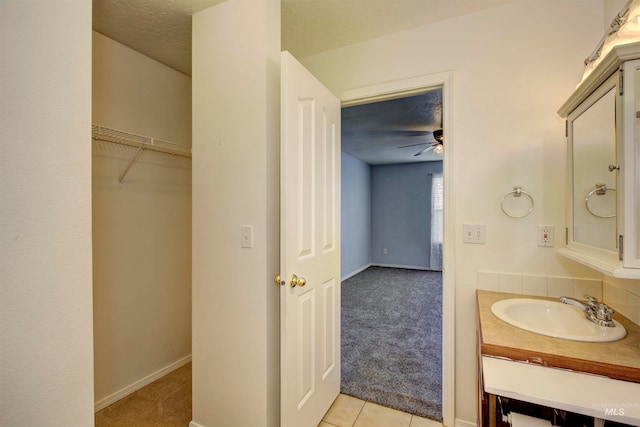 bathroom with a textured ceiling, vanity, tile patterned floors, and ceiling fan