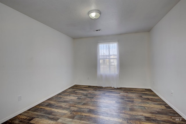 unfurnished room with a textured ceiling and dark wood-type flooring