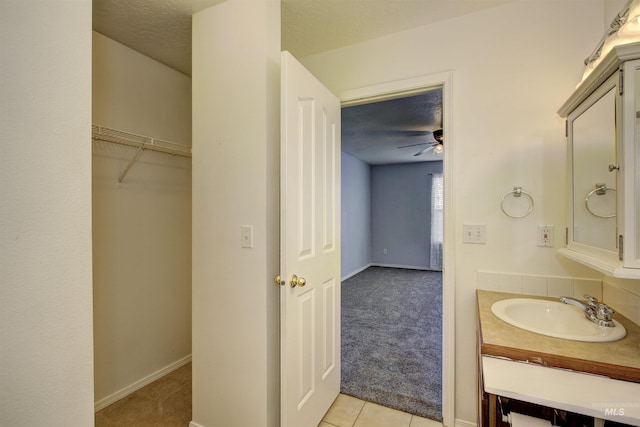 bathroom featuring tile patterned flooring, a textured ceiling, vanity, and ceiling fan