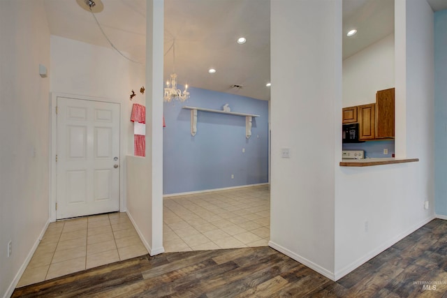 interior space featuring pendant lighting, light hardwood / wood-style floors, vaulted ceiling, and an inviting chandelier