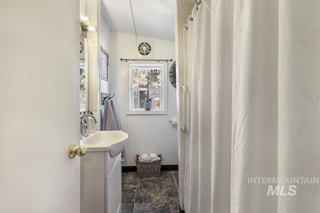 bathroom featuring visible vents, baseboards, and vanity