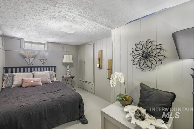 bedroom featuring light colored carpet and a textured ceiling