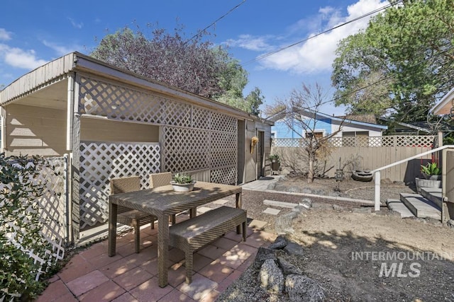 view of yard featuring a patio, outdoor dining area, and fence
