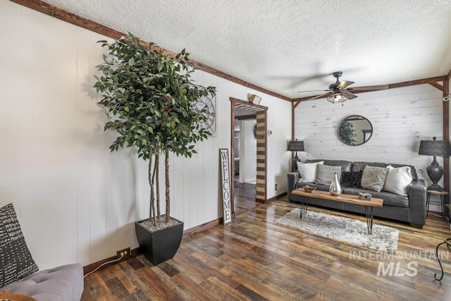 living area with baseboards, a ceiling fan, wood finished floors, and a textured ceiling