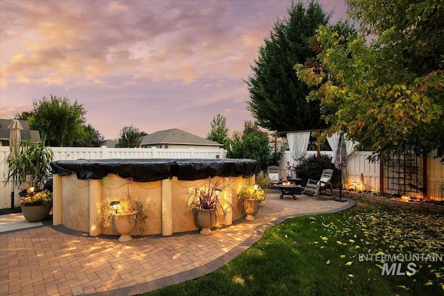 yard at dusk with a patio and an outdoor fire pit