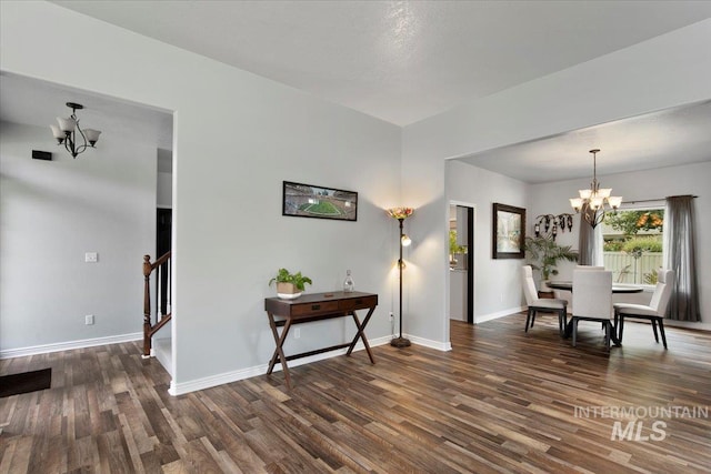 dining area with dark wood-type flooring and a chandelier