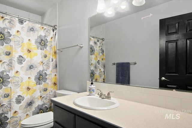 bathroom featuring vanity, toilet, and walk in shower