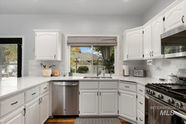 kitchen featuring stainless steel appliances, sink, and white cabinets