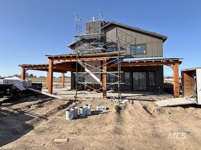 back of house featuring a patio and board and batten siding