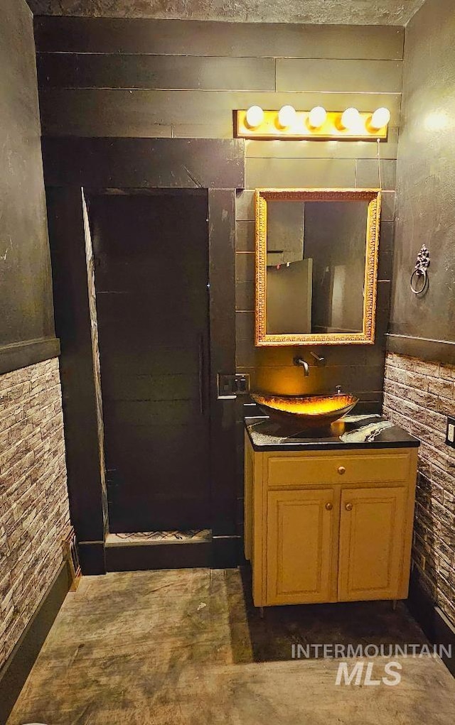 bathroom with brick wall and vanity