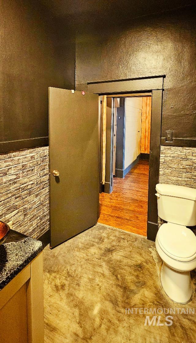bathroom with toilet, wood finished floors, and vanity