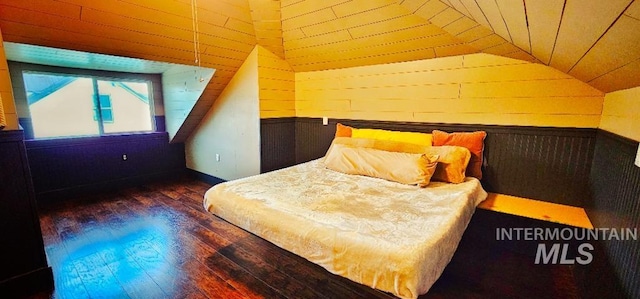 bedroom featuring wood walls, lofted ceiling, and wood finished floors