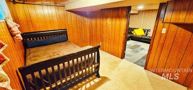 bedroom featuring carpet and wood walls
