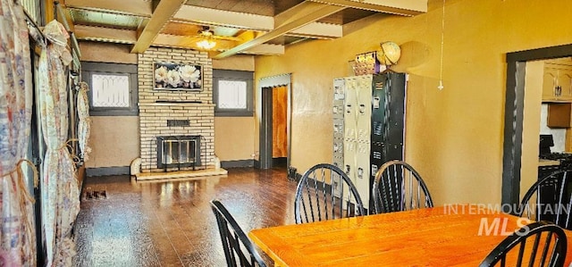 dining space with a ceiling fan, coffered ceiling, beam ceiling, a fireplace, and wood-type flooring