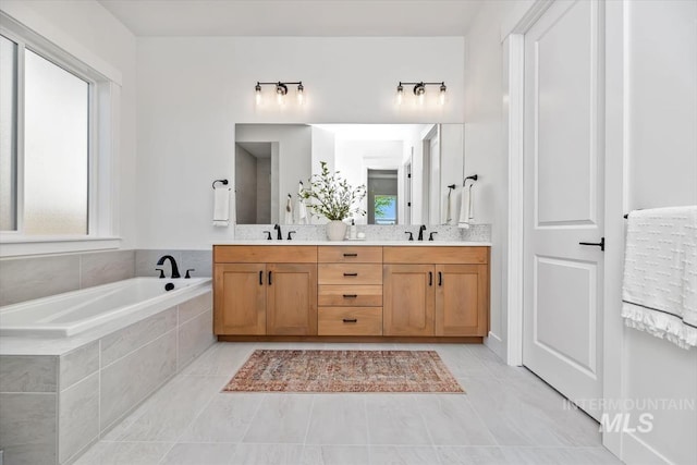 bathroom featuring tile patterned floors, vanity, and tiled tub