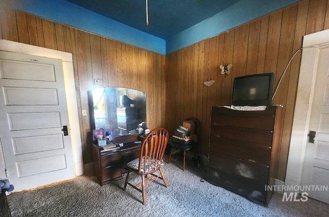 carpeted office featuring wood walls