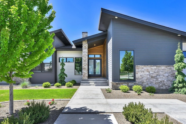 6553 S Pemberley Way, Meridian, ID 83642 - view of front of home with french doors, stone siding, and a chimney