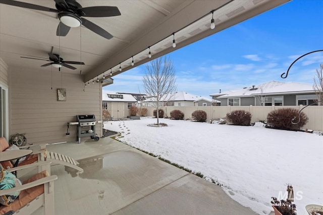 snow covered patio featuring ceiling fan and a grill