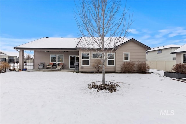 snow covered house featuring a patio