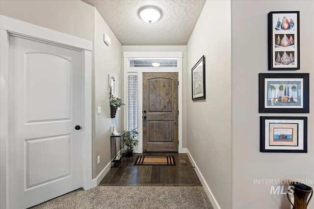 foyer with dark hardwood / wood-style floors and a textured ceiling