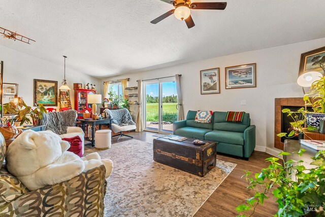 living room featuring a textured ceiling, ceiling fan, vaulted ceiling, and hardwood / wood-style flooring