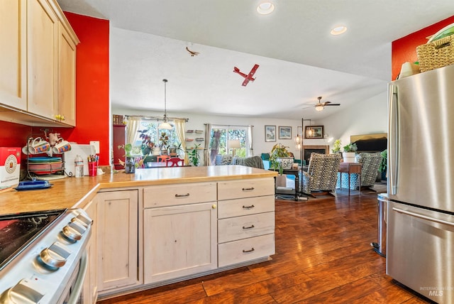 kitchen featuring white stove, dark wood-type flooring, ceiling fan, decorative light fixtures, and stainless steel refrigerator