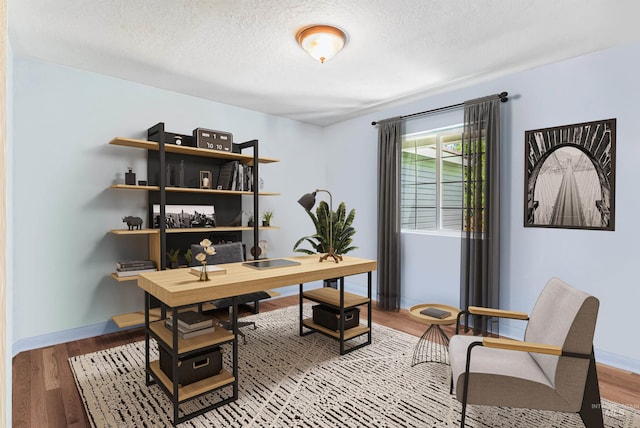 home office with hardwood / wood-style floors and a textured ceiling