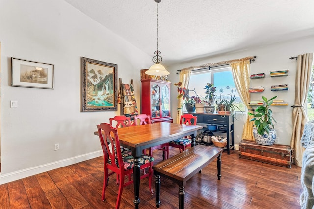 dining space featuring a textured ceiling, dark wood-type flooring, and lofted ceiling