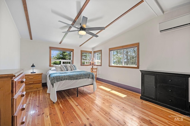 bedroom featuring a wall mounted air conditioner, light wood-type flooring, baseboards, and ceiling fan