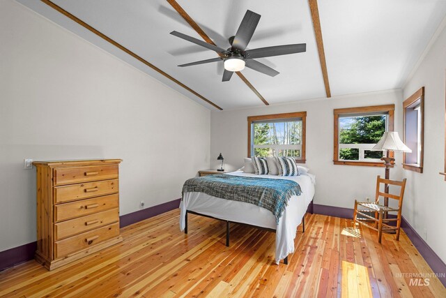 bedroom with light wood-type flooring, vaulted ceiling, and a ceiling fan