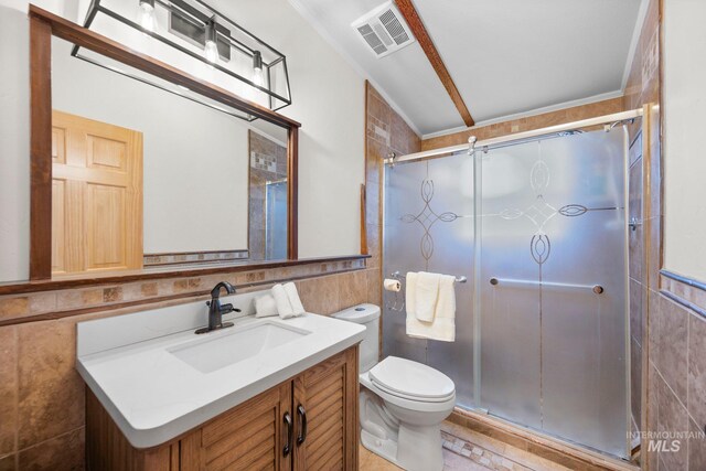 full bath with tile walls, a shower stall, toilet, and vanity
