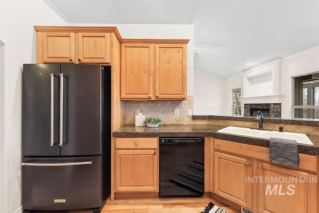 kitchen with lofted ceiling, sink, dishwasher, tasteful backsplash, and high quality fridge