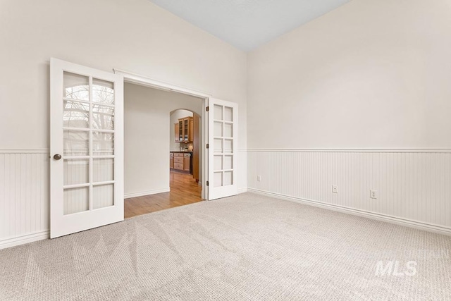 unfurnished room with french doors and carpet