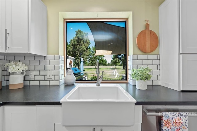 3001 S Roosevelt St Unit 9, Boise, ID 83705 - kitchen with a sink, backsplash, dishwasher, white cabinetry, and dark countertops