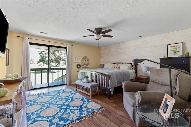 3001 S Roosevelt St Unit 9, Boise, ID 83705 - bedroom featuring access to exterior, wood walls, wood finished floors, a textured ceiling, and a ceiling fan