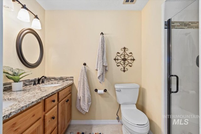 3001 S Roosevelt St Unit 9, Boise, ID 83705 - full bath with double vanity, baseboards, a shower stall, toilet, and tile patterned flooring