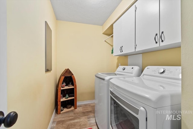 3001 S Roosevelt St Unit 9, Boise, ID 83705 - laundry area with washer and dryer, cabinet space, a textured ceiling, and baseboards