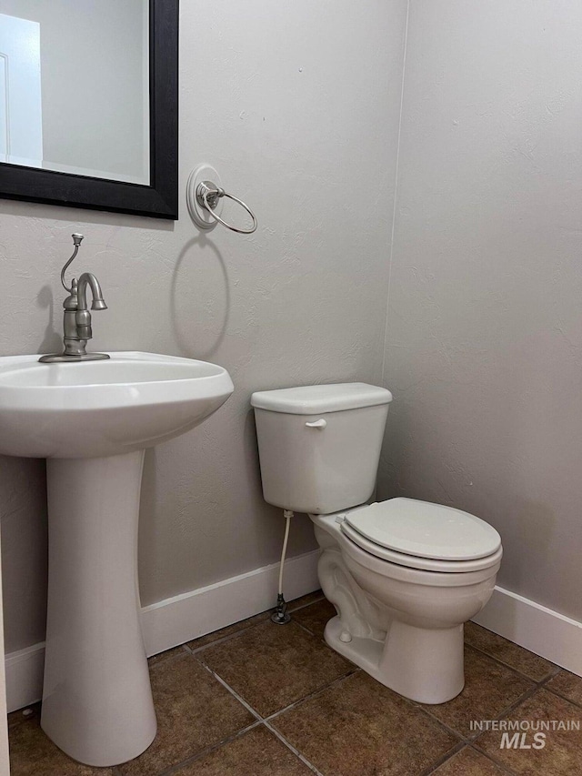 322 Linden Ave, Twin Falls, ID 83301 - bathroom featuring toilet, baseboards, a sink, and tile patterned floors