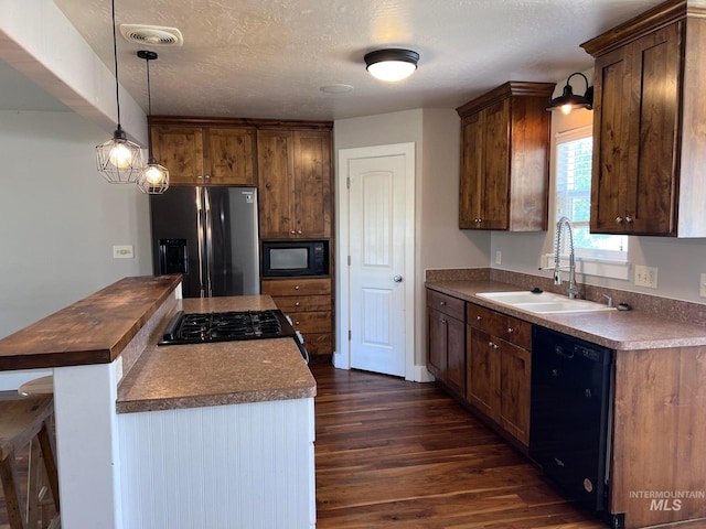 322 Linden Ave, Twin Falls, ID 83301 - kitchen with black appliances, a sink, dark wood finished floors, a kitchen island, and hanging light fixtures