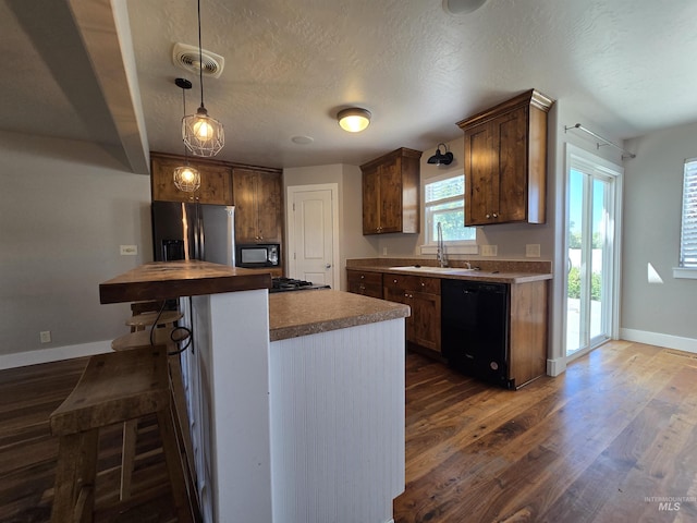 322 Linden Ave, Twin Falls, ID 83301 - kitchen featuring black appliances, a sink, dark wood finished floors, baseboards, and a kitchen bar
