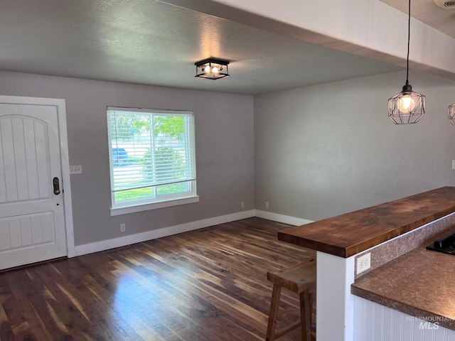 322 Linden Ave, Twin Falls, ID 83301 - unfurnished dining area featuring baseboards and dark wood-type flooring