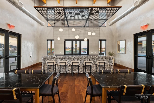 dining space with french doors, dark hardwood / wood-style floors, and a high ceiling