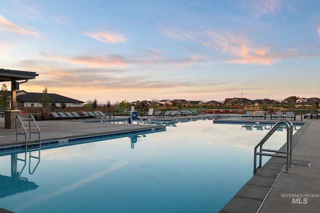 pool at dusk featuring a patio area