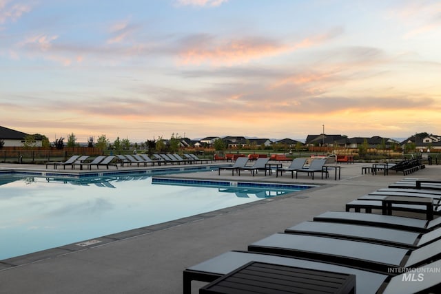 pool at dusk featuring a patio area