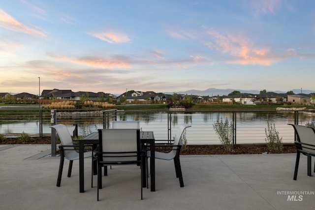 patio terrace at dusk with a water and mountain view